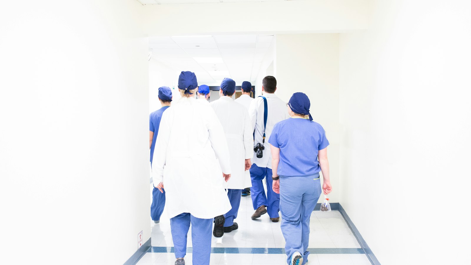 Equipe de plantão caminhando pelo corredor de um hospital